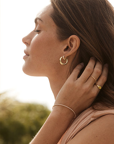 woman wearing gold hoops and huggies