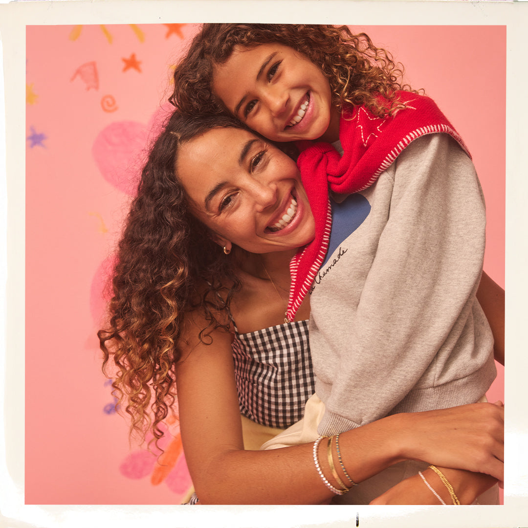 Two people hugging with a pink background featuring stars and shapes