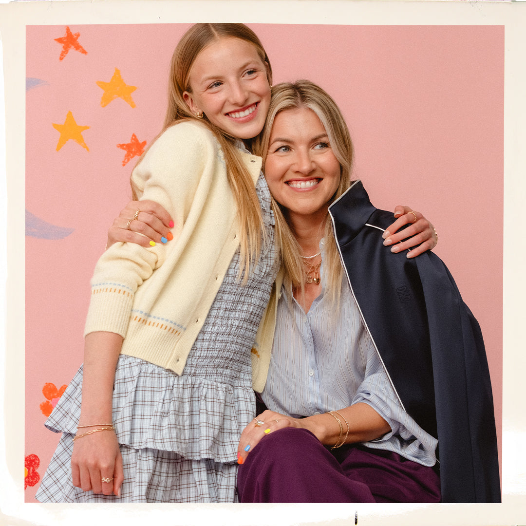 Two women hugging with a pink background featuring star decorations