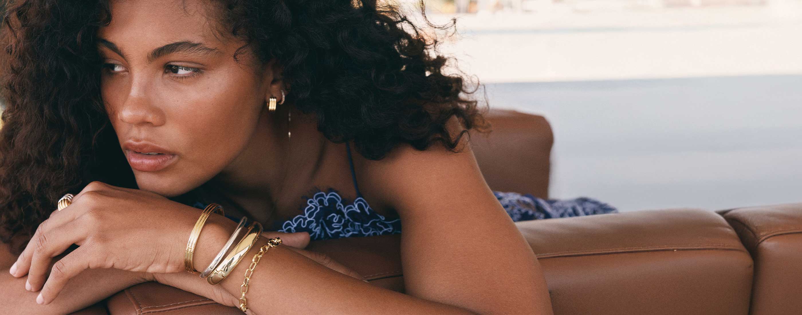 Model wearing statement gold plated earrings and bracelets shop best sellers
