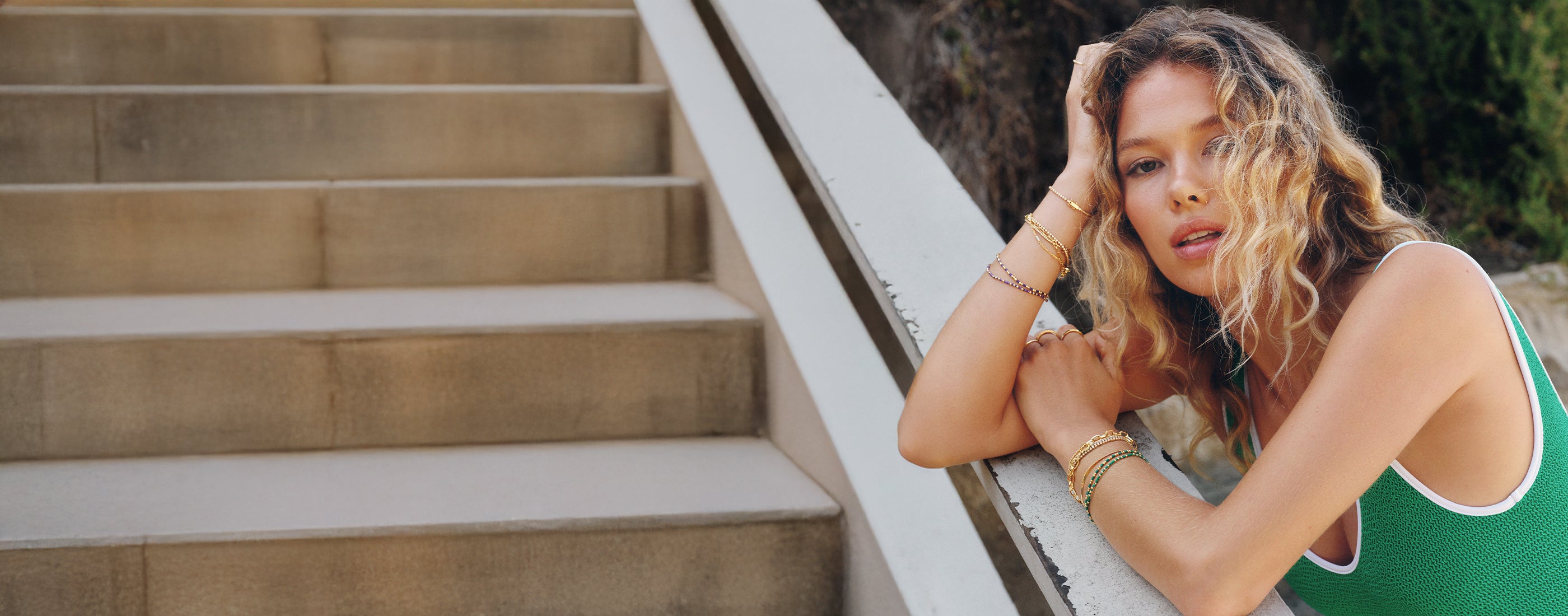 Woman wearing bracelets. Colorful beads and gold plated bangles. 