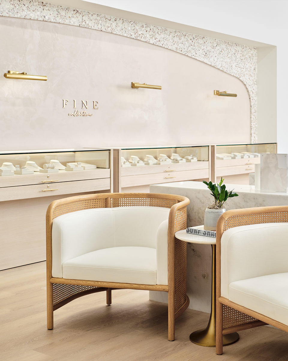 inside of gorjana store with white chairs and side table
