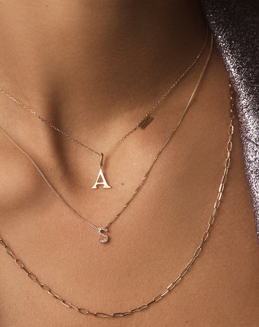 woman in 14k gold initial necklaces