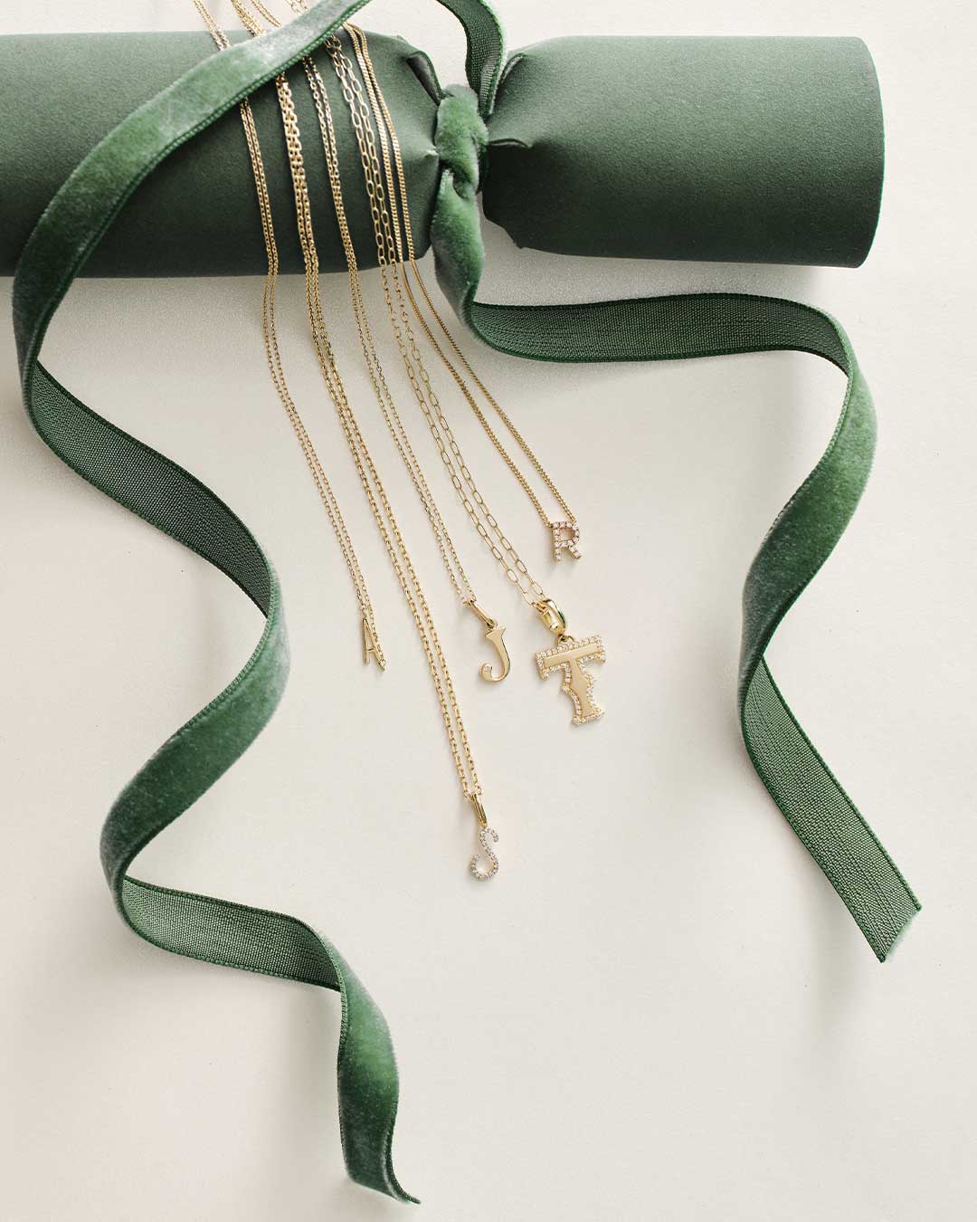 Gold necklaces with a cross pendant on green ribbon