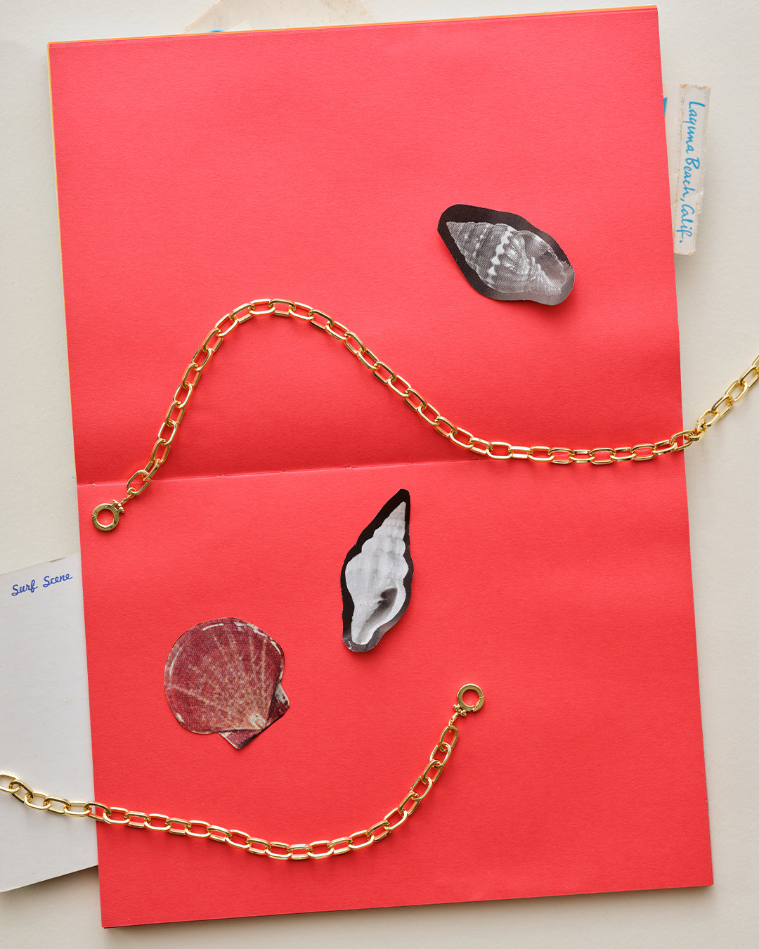 Gold plated chain necklace on paper with shell stickers