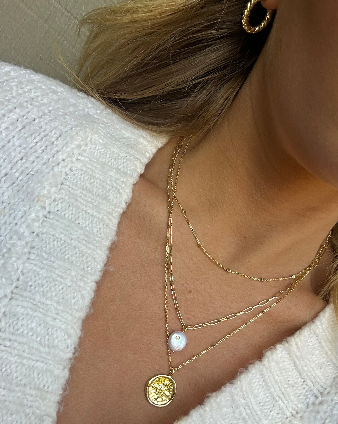 woman wearing gold plated coin and pearl necklaces